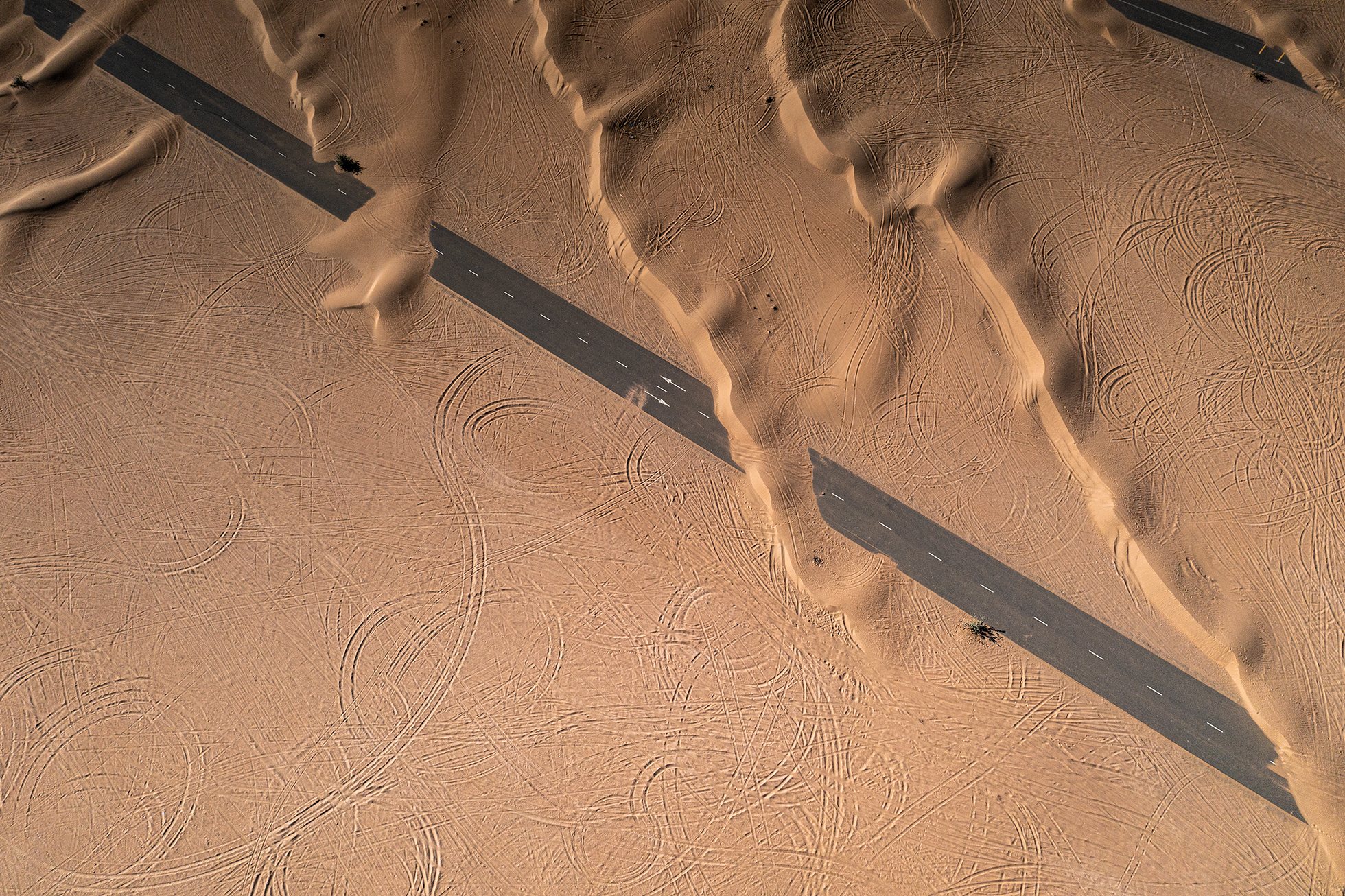 UAE — desert road through the dunes.