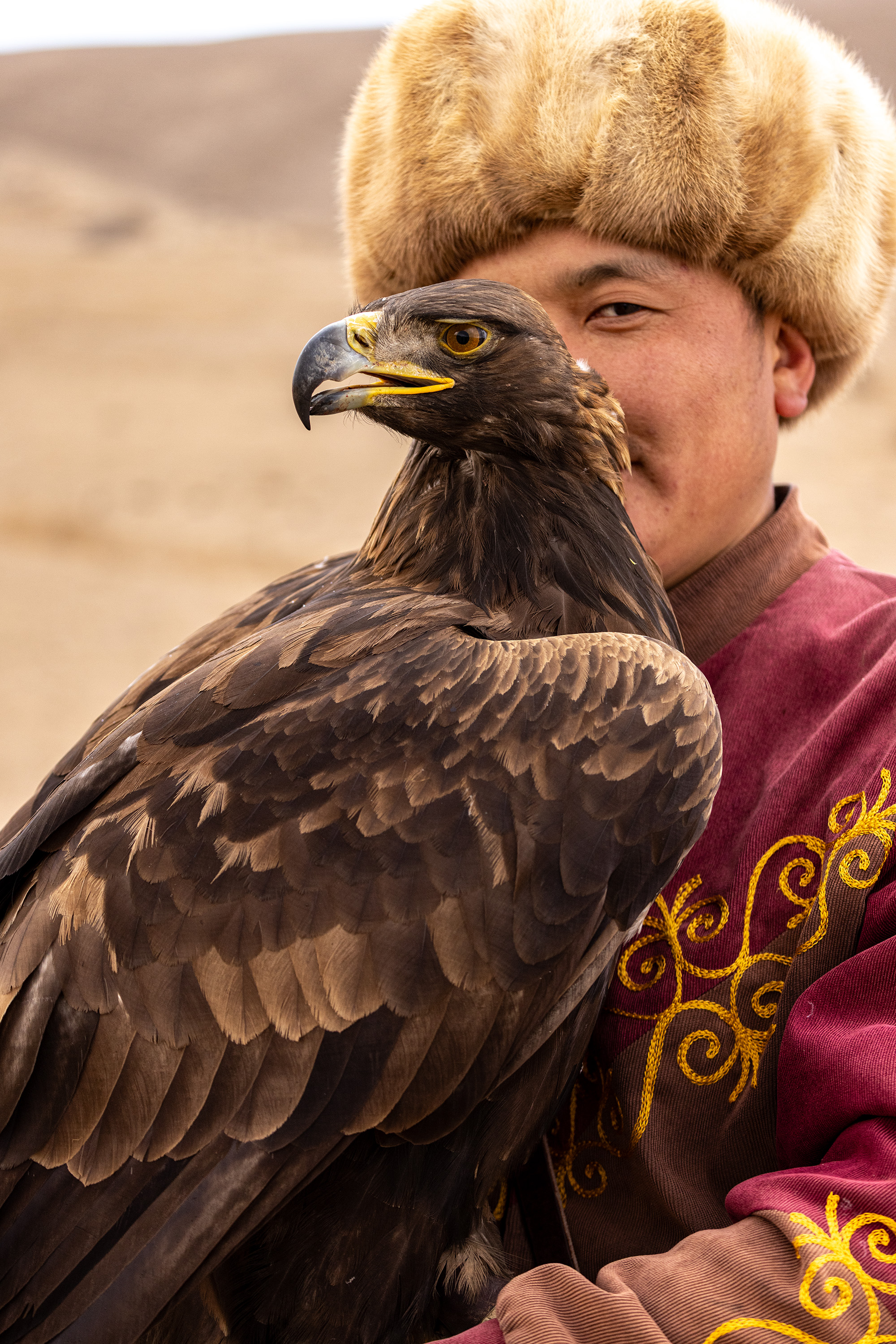 Kyrgyzstan — eagle hunter with golden eagle, portrait